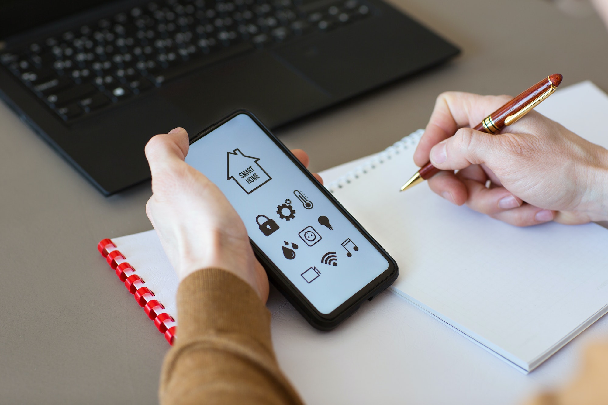 man controls smart home devices using app for mobile phone on background of businessman's work table