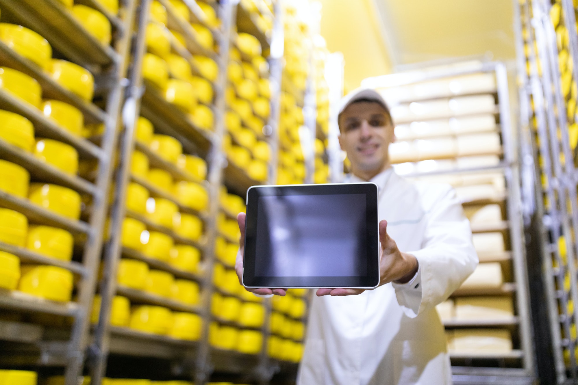 Worker shows an empty screen digitizer in stock cheese